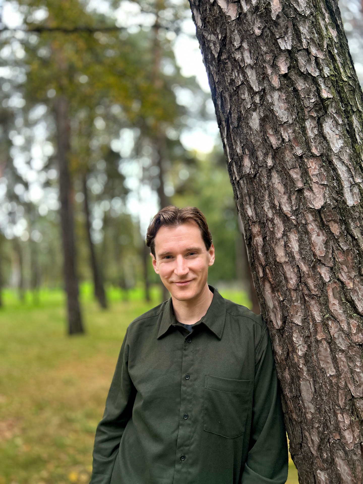 Patrick Zilliacus metsässä männynrungon vieressä